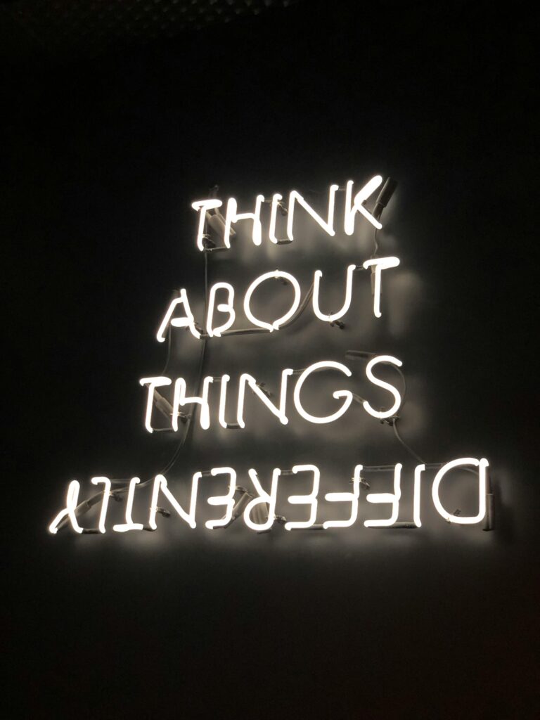 pexels-photo-2681319-2681319 A glowing neon sign displaying an upside-down motivational quote against a dark background.